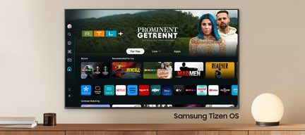 Samsung Tizen OS-Fernsehbildschirm, der eine Benutzeroberfläche mit Apps und zwei Personen im Hintergrund anzeigt