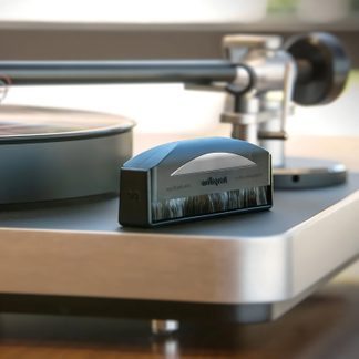 Juoda antistatinė šepetėlis su smulkiais šereliais, stačiakampiu pagrindu, sidabriniu išlenktu paviršiumi, padėtas ant vinilo plokštelės grotuvo.