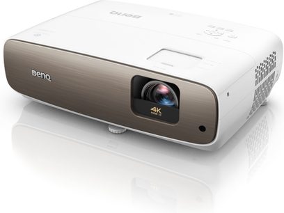 Benq W2700i hvid videoprojektor, set forfra, objektivet er forskudt til højre, knapper på toppen, ventilationsriste på siderne