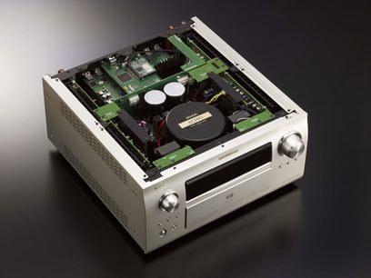 Denon AVC-A1HD sølvfarvet hjemmebiografsforstærker, set forfra i et nedstigende perspektiv med låget åbent, der afslører printplader og interne komponenter