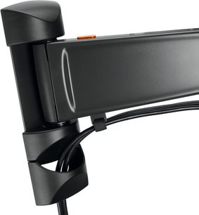 Flad sort vægbeslag til TV, nærbillede af profilvisning af den ledede arm og VESA-monteringen, orange kabel i armen