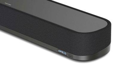 Černý soundbar, pohled ze šikmé strany, tkaninový kryt, zaoblený roh, viditelný logo AMBEO, hladký horní povrch