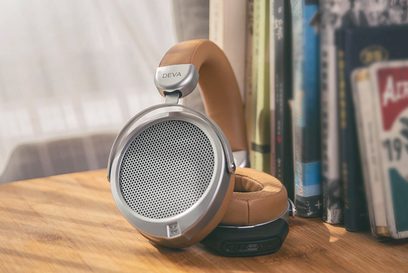 Åbent hi-fi hovedsæt Hifiman Deva i aluminium og brunt læder, set fra siden, placeret på et træbord ved siden af bøger