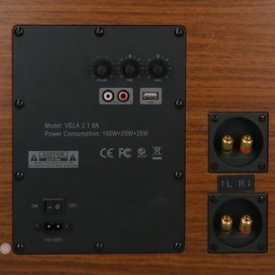 Sada reproduktorů 2.1 VELA 2.1 8A, černý obdélníkový zadní panel, 3 kulatá tlačítka, 2 RCA porty, 1 USB port, 1 vypínač, 2 pozlacené audio svorky, technické nápisy, dřevěný rám