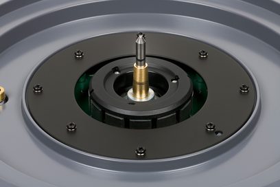 Giradischi Thorens TD 124 DD, vista ravvicinata dall'alto del piatto nero opaco con asse e puntina di lettura in metallo dorato