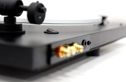 New Horizon 121 sort pladespiller set fra siden, tonarm med pickup, drejende pladespiller med vinylplade
