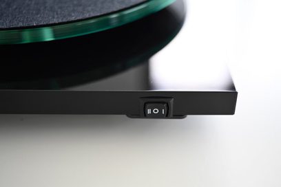 Hi-Fi-levysoitin Pro-Ject T2 Super Phono pähkinäpuulla, vihreällä lasilevyllä ja mustalla kolmiportaisella kytkimellä etureunassa