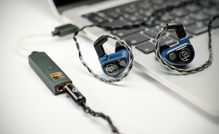 Blå in-ear høretelefoner med snoede kabler på sølvfarvet bærbar tastatur, sort Hi-Res audio DAC
