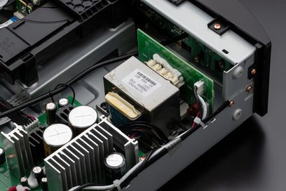 Vista interior de um leitor de CD Marantz CD6007 preto mostrando os componentes eletrônicos, o transformador e o mecanismo de leitura