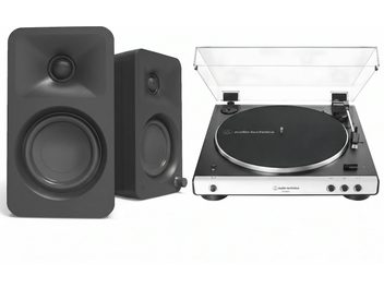 Zwarte en zilveren Audio-Technica-platenspeler met transparante kap en een paar zwarte luidsprekers