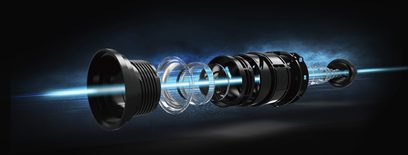 Videoprojektor Optoma CinemaX D2 v bílé barvě, explozní pohled na čočky a vnitřní součásti na tmavě modrém gradientovém pozadí
