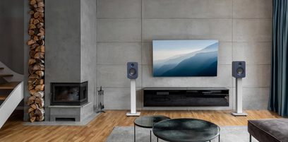 Set aus zwei Kanto REN Smart-Lautsprechern in mattem Blau, rechteckige Gehäuse aus festem Material mit obenliegendem Hochtöner und untenliegendem, kreisförmigem Tieftöner, frontale Ansicht auf weißen Standfüßen