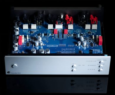 Preamplificator phono Pro-Ject Phono Box DS3 B cu capac deschis, circuit electronic albastru și fațadă argintie