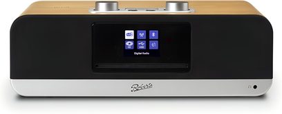 Roberts BluTune 300 bordradio set forfra, rektangulært kabinet med lys træfinér på toppen og sort front, central farveskærm med CD-slit under, sølvfarvet metalbånd foran med logo og jack-stik til højre