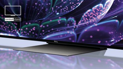 TCL 65C831 2022 TV set forfra, tændt skærm der viser farvede abstrakte former på sort baggrund