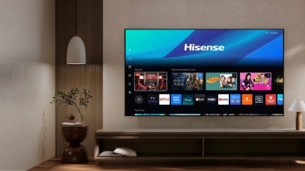 Hisense fladskærms-tv monteret på væggen, smart-tv-interface vist i en moderne stue