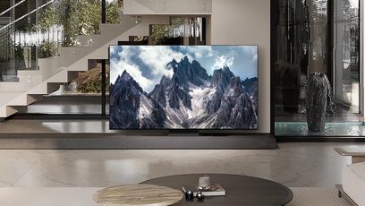 Samsung F-TQ77S95D-BF højdefinitions-tv, rektangulær skærm, billede af bjerge, placeret på lavt møbel, moderne trappe til venstre, sort skulptur til højre, lys marmorgulv