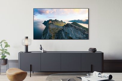 Televizor s plochou obrazovkou v matné černé barvě, ultra tenký rám z hladkého kovu nebo plastu, pohled zepředu, upevněný na stěnu