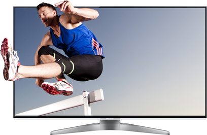 Atlet, der springer foran et tændt Panasonic TX-L47WT50 TV set i frontperspektiv på grå baggrund