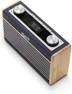 Radio da tavolo Roberts Rambler Uno blu navy, corpo in legno chiaro con frontale a griglia metallica argentata, parte superiore nera dotata di uno schermo centrale e due grandi pulsanti rotondi in alluminio, vista da tre quarti superiore anteriore