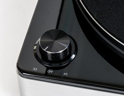 Elac Miracord 60 sort, tæt påbillede i vinkel på metalvælgeren 33/45, kanten af pladespilleren og den børstede metalflanke