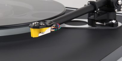 Rega Exact gul og sort vinylpladespiller-celle, tæt profilvisning af den matsorte tonarm