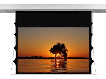 Pantalla motorizada empotrable desplegada en un marco negro, mostrando una puesta de sol anaranjada detrás de un árbol a la orilla del agua