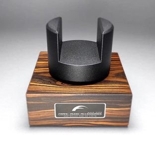 Stojak na kable Franc Audio Accessories, wykonany z drewna i matowego czarnego metalu, w formie cylindrycznej, pustej w środku, na drewnianej podstawie