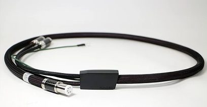 Černý audio kabel se stříbrnými kovovými konektory na koncích, tvořící smyčku na bílém pozadí