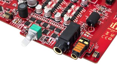 Aukštos kokybės ausinių stiprintuvas iFi Audio ZEN CAN 3, vaizdas iš viršaus, raudona elektroninė plokštė, įvairūs komponentai, garso jungtys, sidabrinis potenciometras, cilindriniai kondensatoriai, juodi integruoti grandynai