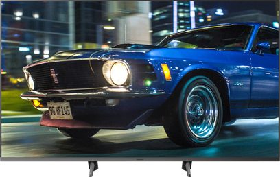 Panasonic TX-58HX800E 58" 4K UHD-tv, der viser en blå 1969 Ford Mustang parkeret på en gade om natten