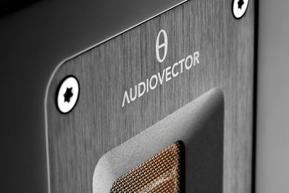 AudioVector QR1 sort højttaler, klaverlakeret, nærbillede af forsiden med logo og metalrist
