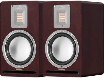 Coppia di diffusori da scaffale AudioVector QR1 SE in noce con finitura in legno marrone noce, cono dei bassi in alluminio argentato, tweeter a nastro rettangolare incassato su piastra metallica ed elemento reflex frontale a fessura, vista di tre quarti anteriore