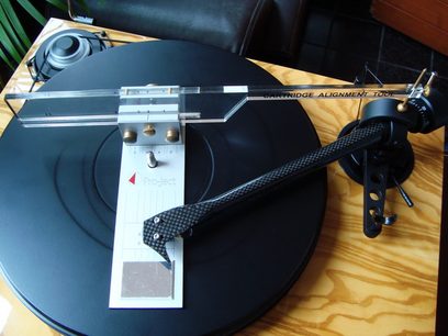 Pro-Ject Align it, sort, med leddet arm, på sort pladespiller, set ovenfra