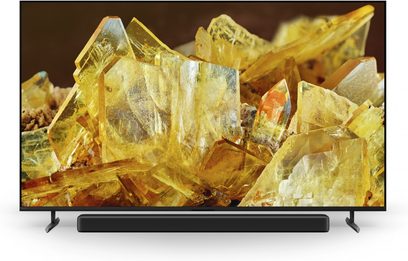 Sony XR85X90L fladskærms-tv set forfra, skinnende gule krystaller vist, sort stander synlig nederst
