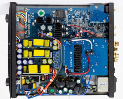 Interiorul unui aparat audio din metal, vedere de sus, plăci albastru, condensatoare, radiatoare negre, cabluri multicolore