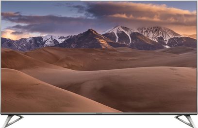 Televisor Panasonic TX-58DX730E exibindo uma paisagem montanhosa desértica ao pôr do sol