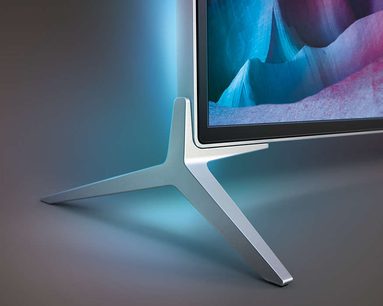 Philips 49PUS7100 TV set fra siden, blå og hvid skærm tændt, sølvfarvet Y-formet metalfod