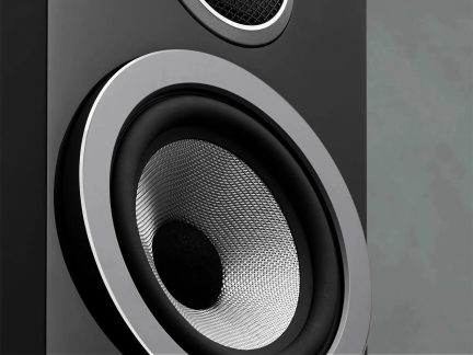 Svart hi-fi-høyttaler sett på nært hold, stor sølvfarget høyttaler med flettet tekstur og diskanthøyttaler på fronten