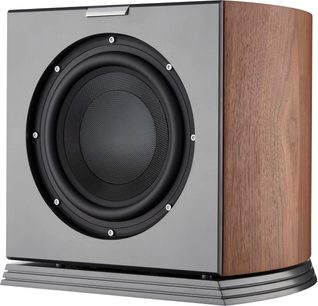 AudioVector RSUB subwoofer i valnød, set fra trekvart forfra, kabinet i valnøddetræ med buede sider, front i antracitgrå med stor sort cirkulær højttaler omgivet af synlige skruer, placeret på en mørkegrå sokkel