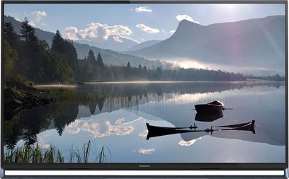 Fladskærms-tv, der afspejler et landskab med en sø og skovklædte bjerge ved solopgang eller solnedgang, med en robåd i forgrunden