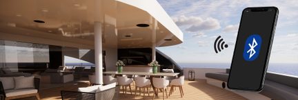 Smartphone con logo Bluetooth visualizzato sullo schermo, posato su un tavolo in un interno di yacht di lusso