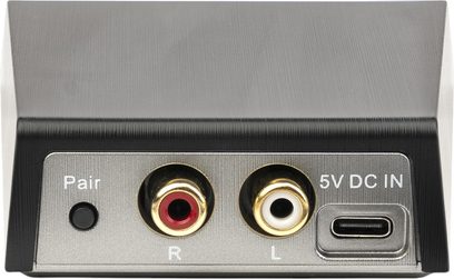 Trasmettitore wireless MartinLogan WSK1E nero in metallo spazzolato, vista posteriore ravvicinata, con pulsante Pair nero, due prese RCA dorate rosse e bianche contrassegnate R e L, e porta di alimentazione USB-C 5 V