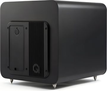Q Acoustics Q SUB100 matte black subwoofer enclosure, cube-shaped with rounded edges and a smooth finish, featuring a finned rear panel, circular logo, and four metal conical feet, rear three-quarter left view