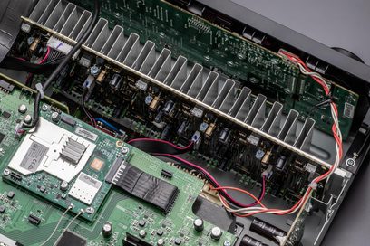 Carte électronique verte avec composants électroniques, circuits imprimés et câbles multicolores dans un boîtier métallique noir