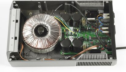 Cyrus PSX-R sort strømforsyning set ovenfra, der viser printplade, toroidaltransformer og kondensatorer