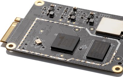 Šedý elektronický obvod s pozlacenými elektronickými součástkami, dvěma černými čipy a pozlacenými konektory na okrajích