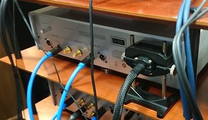Furutech NCF Booster audio accessory in black metal and plastic, rear view showing blue connectors and cables