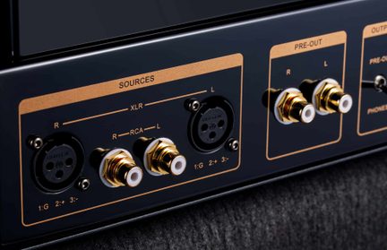 Primo piano obliquo del pannello posteriore in metallo nero, prese XLR nere e RCA dorate, aree SOURCES e PRE-OUT