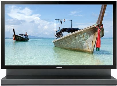 Panasonic TH-103PF12EK fladskærms-TV, frontvisning, placeret på et stativ, viser et billede af en strand med strandede både